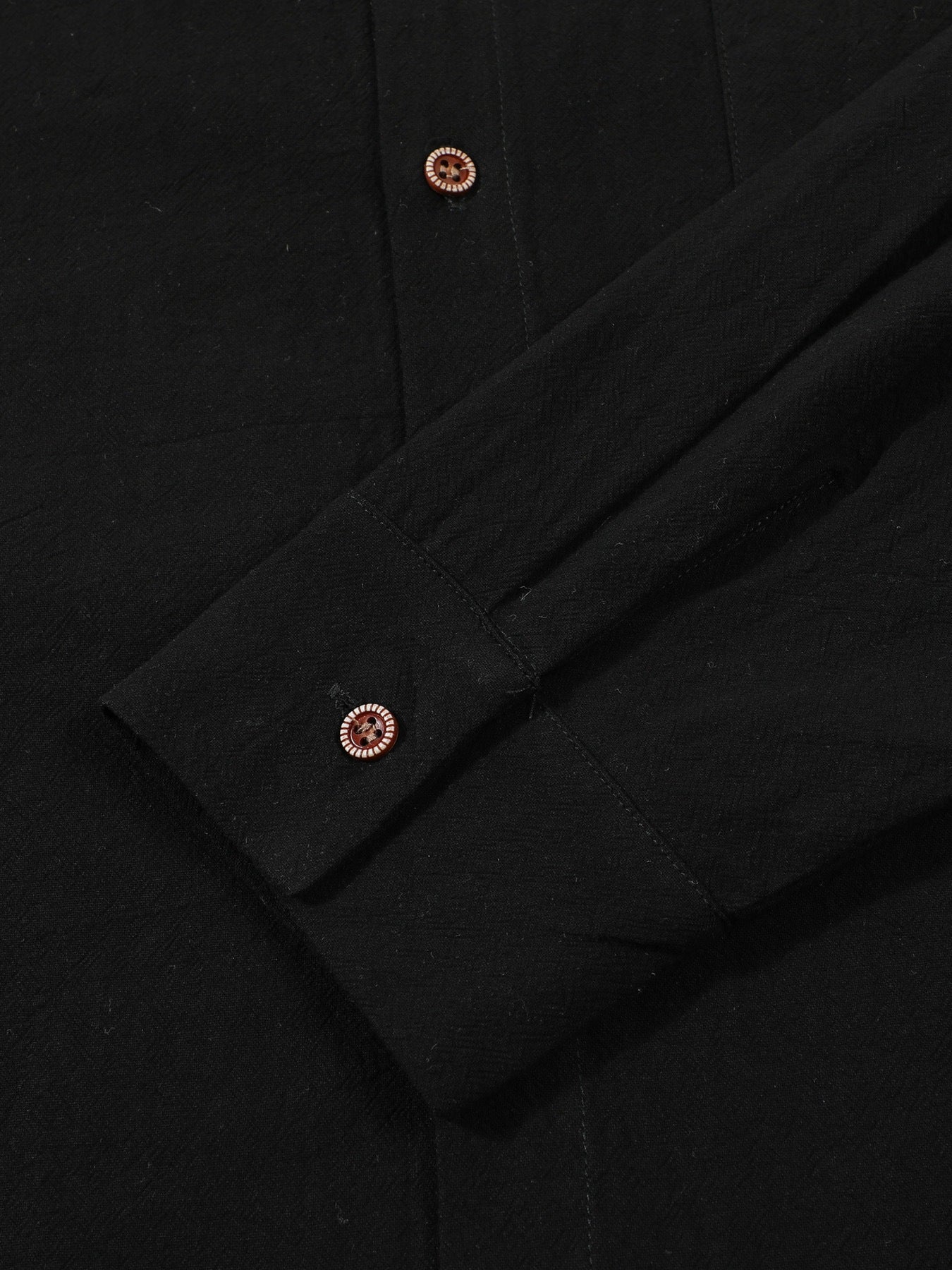 Close-up of black linen shirt cuff and button detail